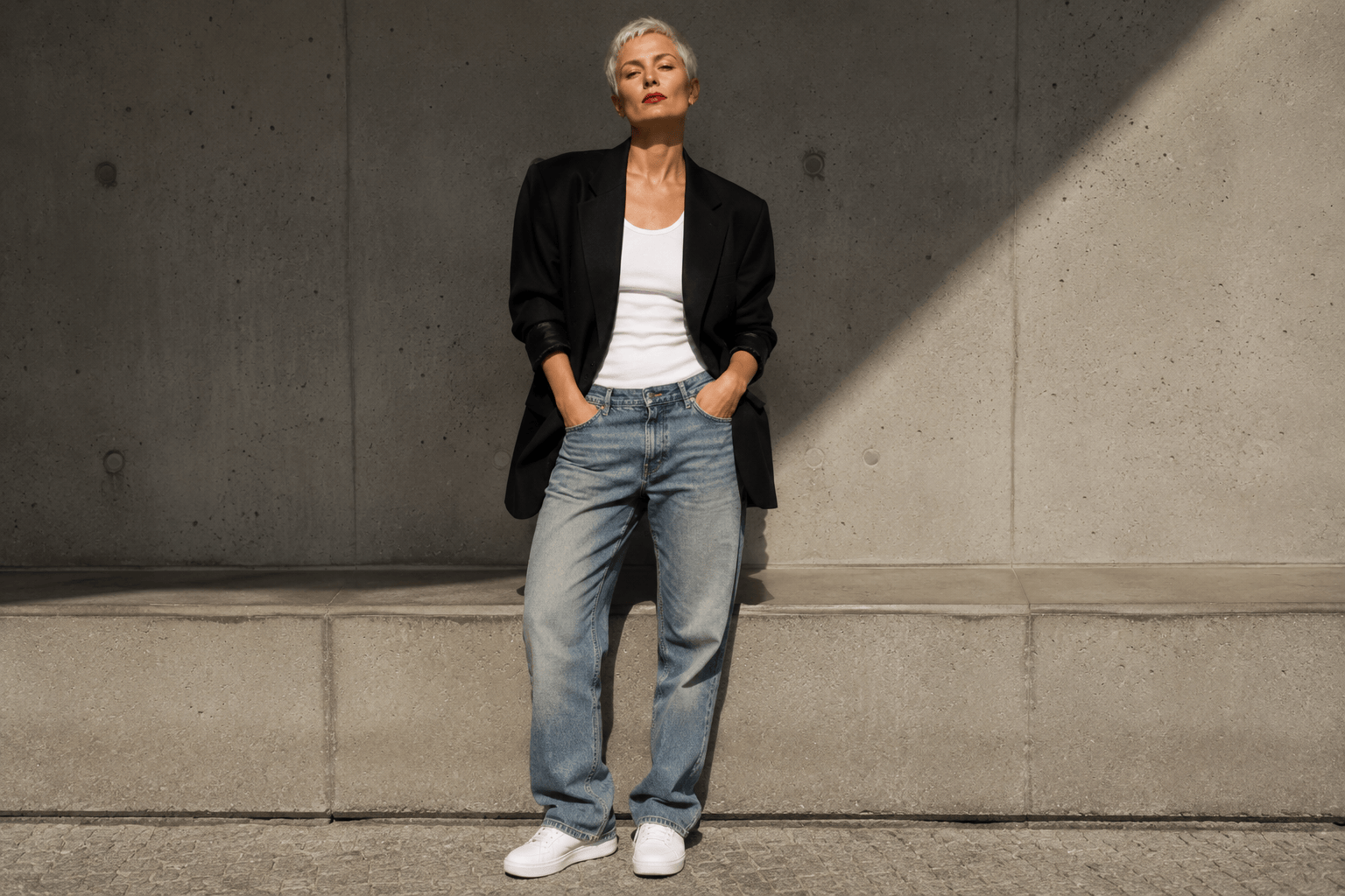Burmese-American woman with high ponytail on a Manhattan corner in a long-line camel double-breasted blazer over a white silk slip