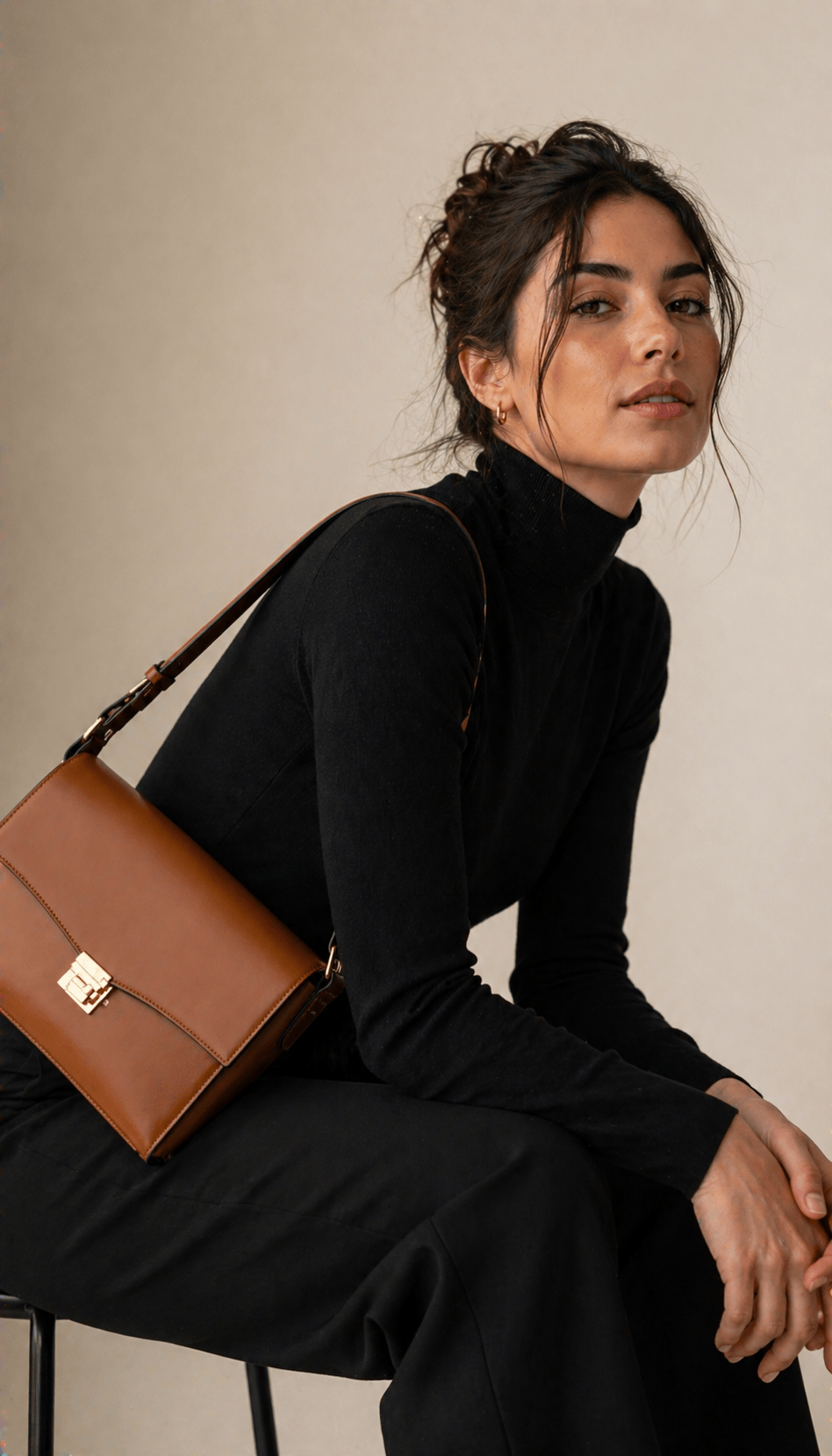Filipina woman in her thirties walking through a marble-floored hotel lobby with a structured caramel pebbled-leather shoulder bag held at the elbow